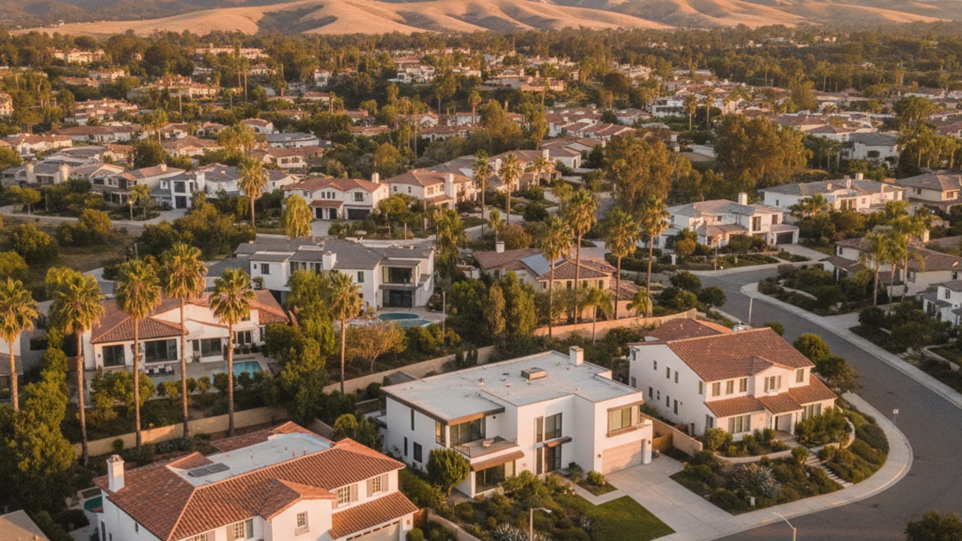 Aerial view of a San Diego County residential neighborhood with stucco homes and mature tree-lined streets at golden hour